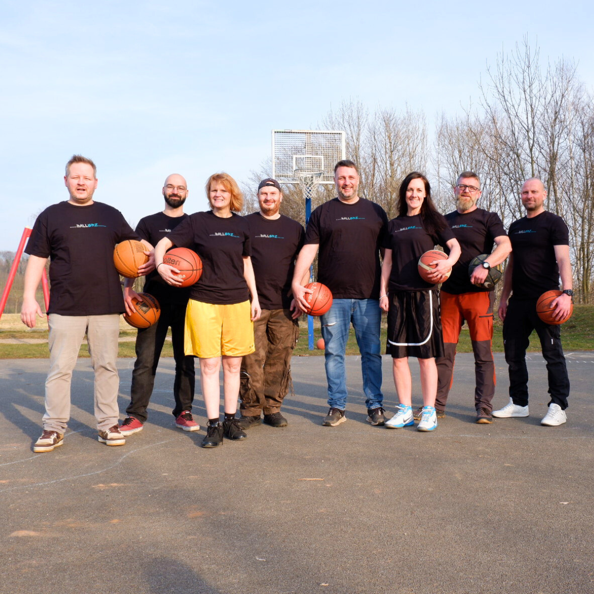 Gruppenbild der Gründungsmitglieder der Ballerz. 6 Männer und 2 Frauen in Sportkleidung stehen mit Basketbällen auf Basketballplatz