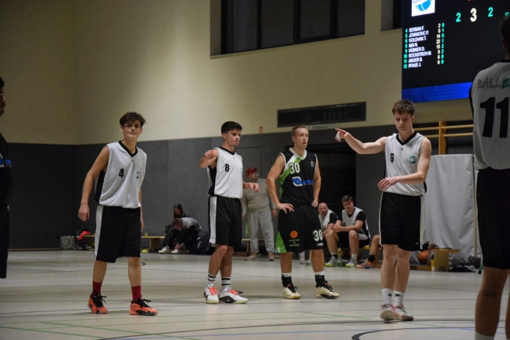 Drei Spieler der Ballerz auf dem Spielfeld, unterhalten sich